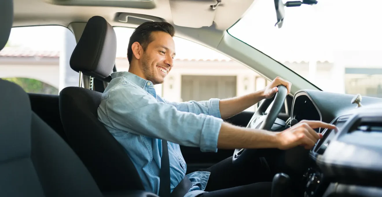 Un conducteur vérifie le compteur kilométrique dans une voiture stationnée.
